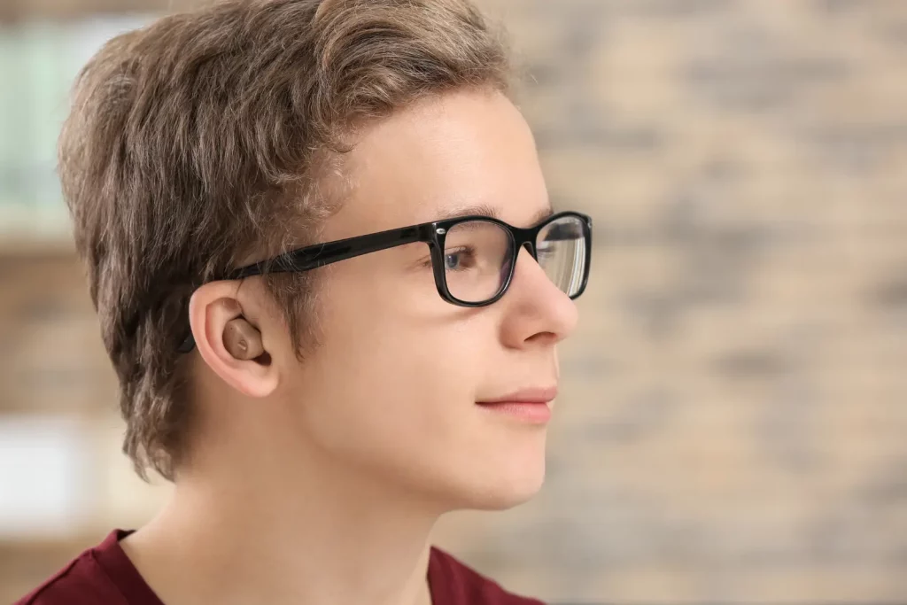 Appareil auditif intra-auriculaire porté par un jeune homme.